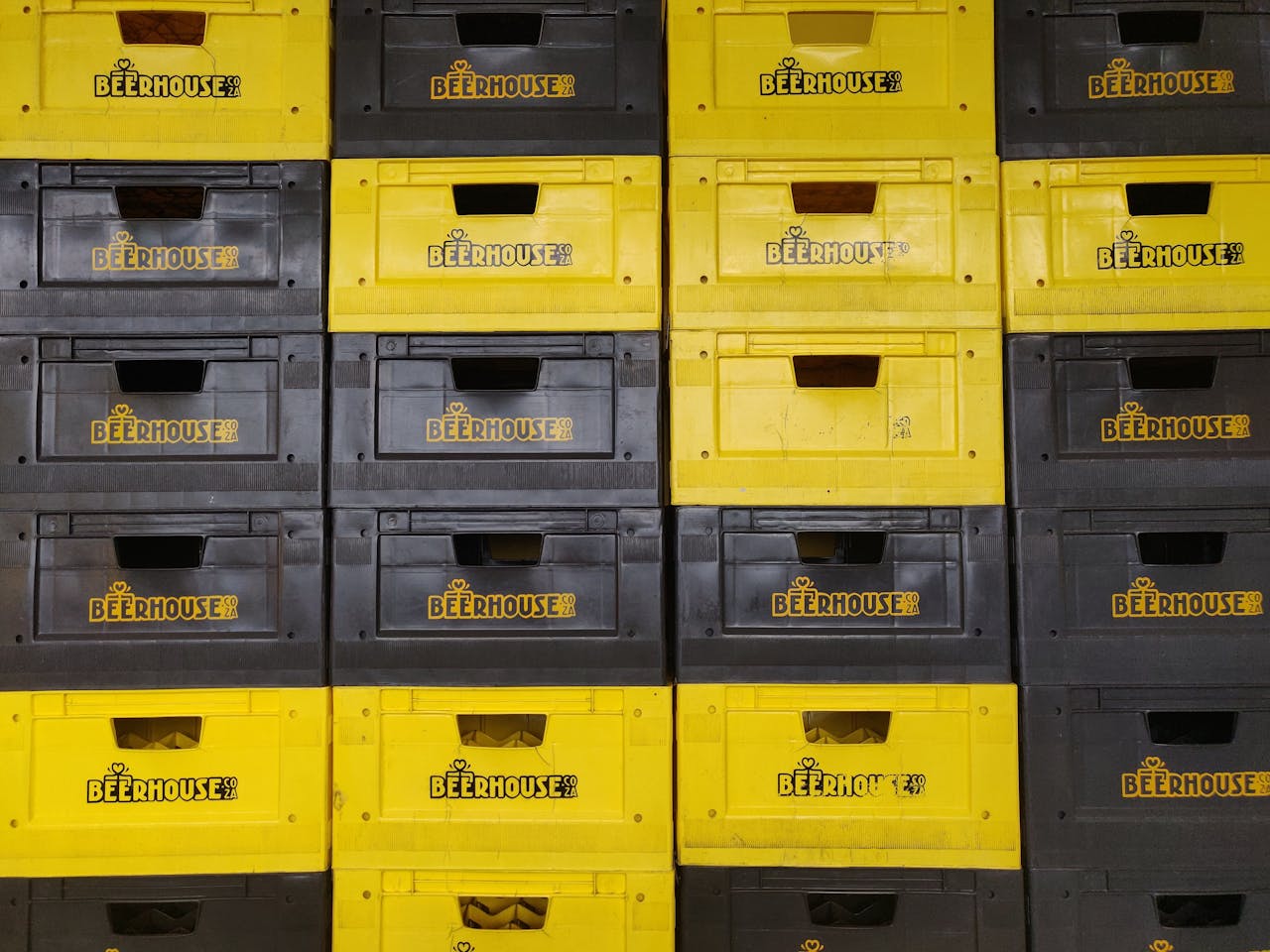 Rows of yellow and black Beerhouse crates in a Cape Town warehouse.